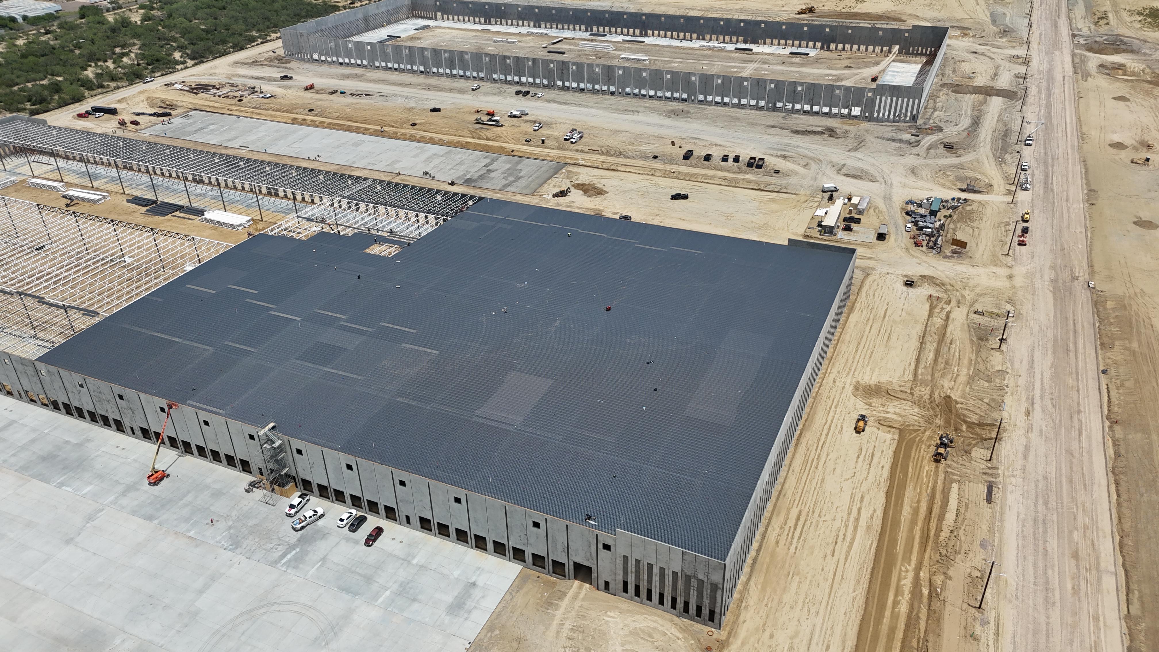 Aerial view of a roofed distribution building with adjacent concrete truck court paving