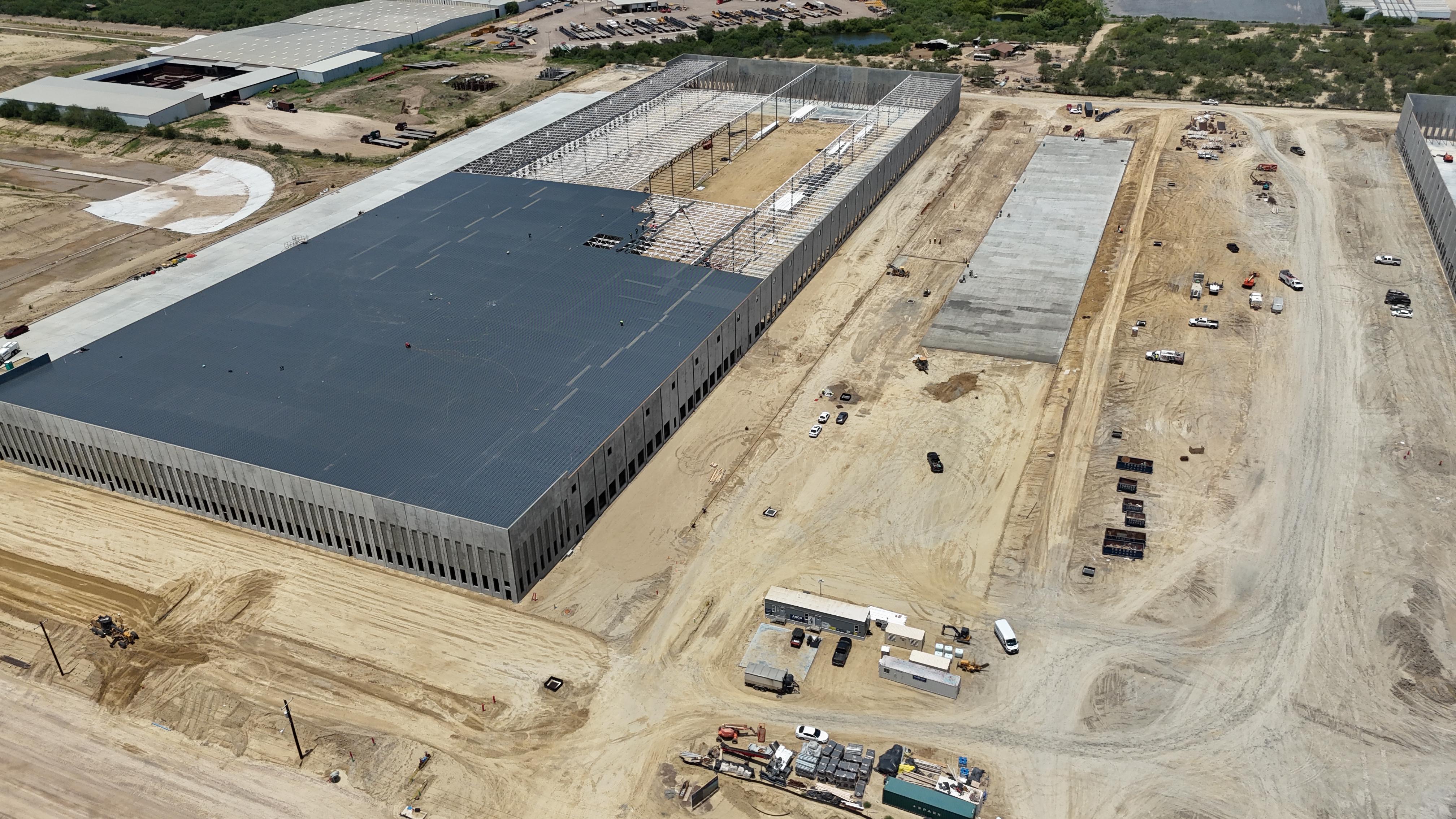 Aerial view of a warehouse under construction with poured concrete dock apron and steel joists